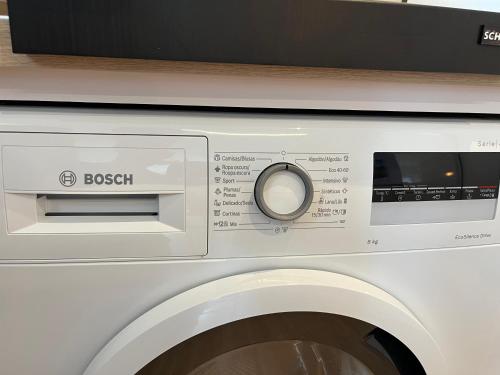 a white washing machine with a microwave on top of it at Duplex con terraza privada y parking a 15 minutos de Sevilla in Dos Hermanas