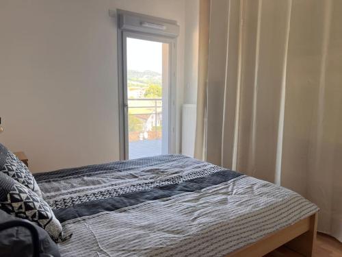 - une chambre avec un lit et une fenêtre dans l'établissement t2 Gex Centre, proche Genève et station Mont Jura, à Gex