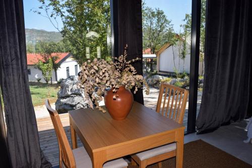 a vase sitting on a table in a room with a window at Oblun Eco Resort - Mirror Cabin in Podgorica