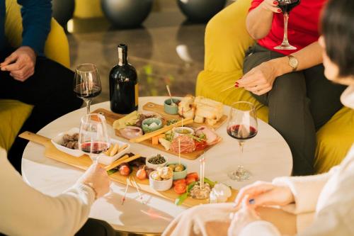 a group of people sitting around a table with food and wine at Santa Lucia Boutique Hotel in Santa Luċija