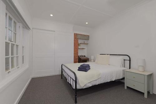a white bedroom with a bed and a window at Manuka Village - Sleeps 8 - Free parking x 4 in Kingston 