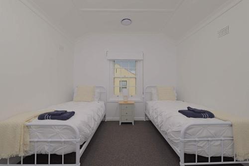 two twin beds in a room with a window at Manuka Village - Sleeps 8 - Free parking x 4 in Kingston 