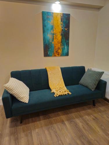 a blue couch in a living room with a painting at Su Casa - Rezerva acum apartament Spatios ultracentral, ceai, cafea, filtru apa rece-fierbinte, parcare gratuita in zona in Craiova