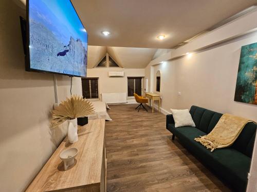 a living room with a green couch and a flat screen tv at Su Casa - Rezerva acum apartament Spatios ultracentral, ceai, cafea, filtru apa rece-fierbinte, parcare gratuita in zona in Craiova