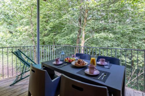 a table with a plate of food on a balcony at Le Sureau Noir S24B - Le Val Joly in Eppe-Sauvage