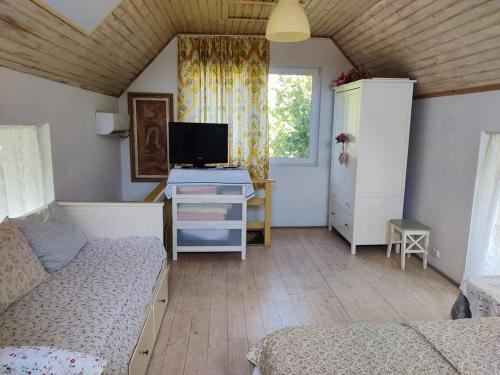 a bedroom with a desk with a computer and a bed at Garden House in Ciorogârla
