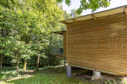 a wooden building with a balcony on the side of it at Le Sureau Noir S24A - Le Val Joly in Eppe-Sauvage