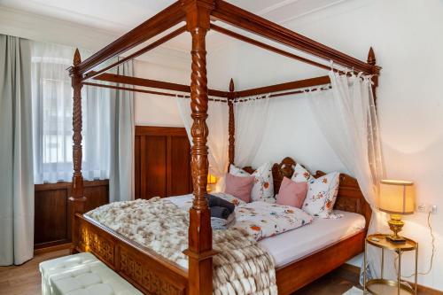 a bedroom with a wooden canopy bed with pillows at Apartment Villa Stumm in Stumm