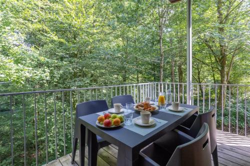 une table avec un bol de fruits sur un balcon dans l'établissement Le Sureau Noir S23B - Le Val Joly, à Eppe-Sauvage