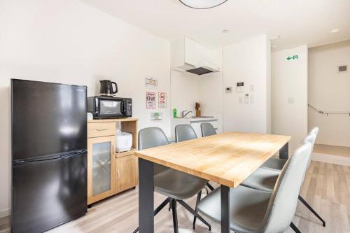 Una cocina con mesa y sillas y un refrigerador. en 新井1丁目, en Tokio