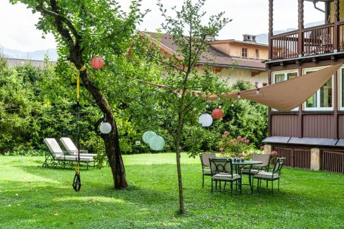 a garden with a table and chairs and an umbrella at Apartment Villa Stumm in Stumm