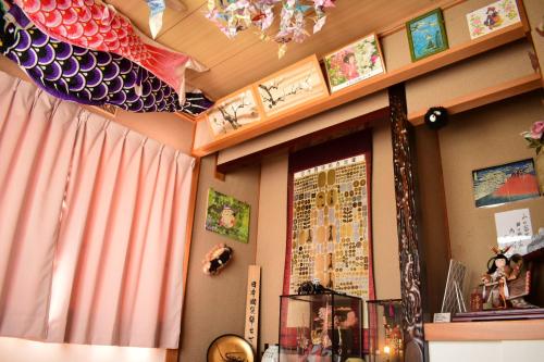 a room with a window with a fish on the wall at OMOLOSO Hostel　オモロソウ ホステル in Beppu