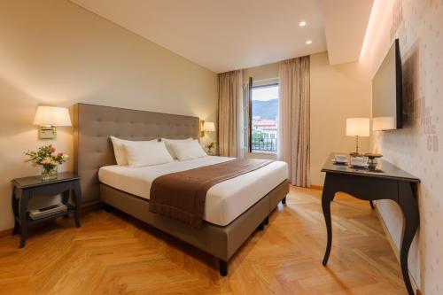 a hotel room with a bed and a window at Palace Hotel Lake Como in Como