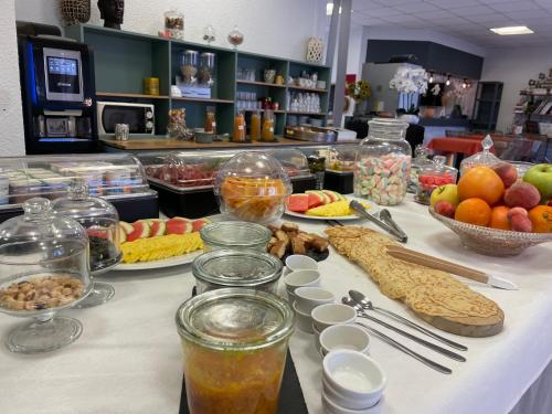 a buffet with fruit and other food on a table at Cit'Hotel des 2 Golfs in Port Leucate