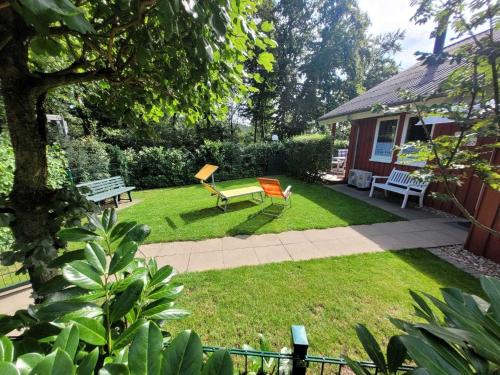 a backyard with a bench and a table and chairs at Gemütliches Ferienhaus in Rott mit Sauna, Grill und Terrasse in Extertal