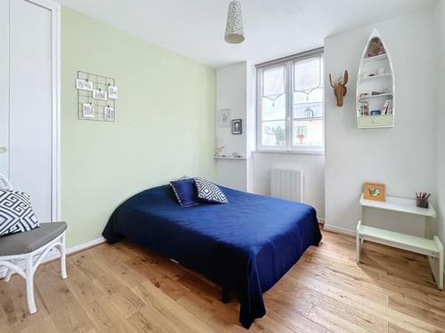 - une chambre avec un lit bleu et une chaise dans l'établissement Jadis, l'école de Maisy, port et plage au bout de l'avenue, à Grandcamp-Maisy