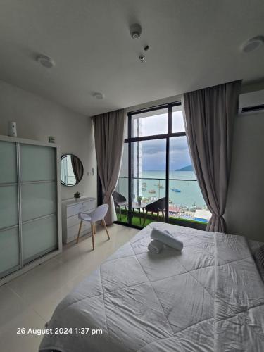 a bedroom with a large bed with a view of the ocean at The Shore SeaView Center Kota Kinabalu Home Suites Studio in Kota Kinabalu