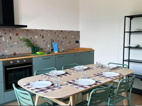 a kitchen with a wooden table with plates and chairs at Luci fra le nuvole in Colico