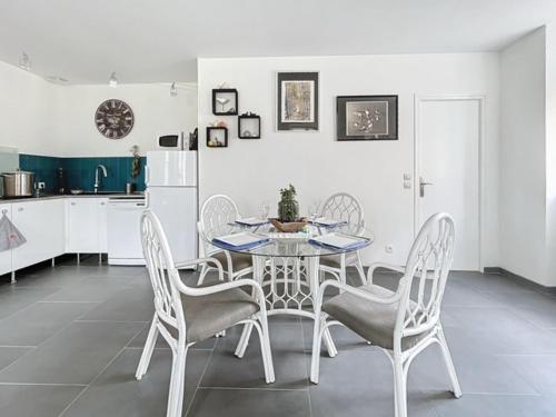 une salle à manger avec une table et des chaises dans une cuisine dans l'établissement Jadis, l'école de Maisy, port et plage au bout de l'avenue, à Grandcamp-Maisy
