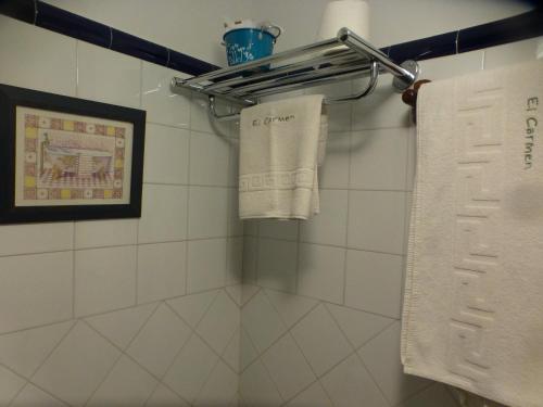 a bathroom with white towels hanging on a rack at Hotel El Carmen in Ribadesella