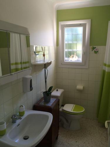 une salle de bain avec un lavabo et des toilettes et une fenêtre dans l'établissement Rez-De-Jardin Villa - Proche Plages & Port, à Cavalaire-sur-Mer