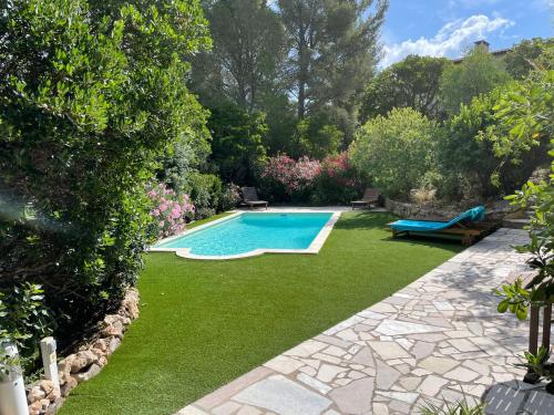une cour avec une piscine et de l'herbe verte dans l'établissement Rez-De-Jardin Villa - Proche Plages & Port, à Cavalaire-sur-Mer