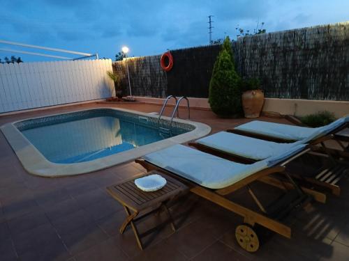 une piscine avec deux chaises longues à côté dans l'établissement Mas Japimon, à Creixell