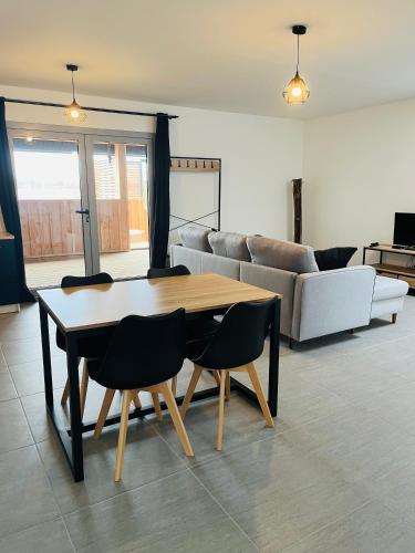 Una sala de estar con una mesa y sillas y un sofá. en Spa, en Marcheprime