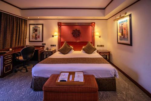 a hotel room with a large bed and a desk at Kampala Serena Hotel in Kampala