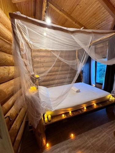 a bed in a wooden room with a net at MaviLand Chalet in Bran