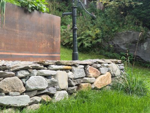 a stone wall with a street light behind it at Nostalgie Bed & Breakfast Chrämerhus in Curaglia