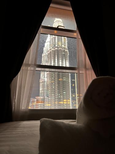 a bedroom window with a view of a tall building at Sky Suites at KLCC by Mitstay in Kuala Lumpur