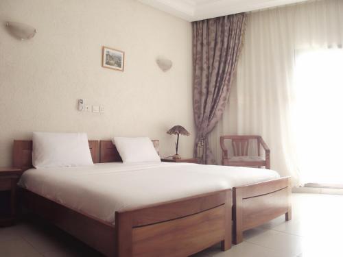 a bedroom with a large bed with white sheets at Hotel Ghis Palace in Baguida
