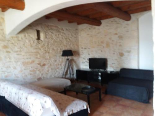 un salon avec un lit et un canapé dans l'établissement Maison de village dans Languedoc-Roussillon, à Vergèze