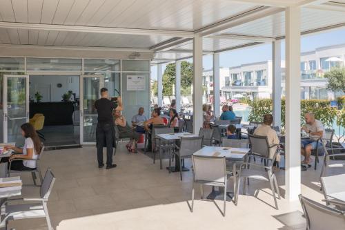 a man standing in a restaurant with people sitting at tables at Maj Luxury Residence in Poreč