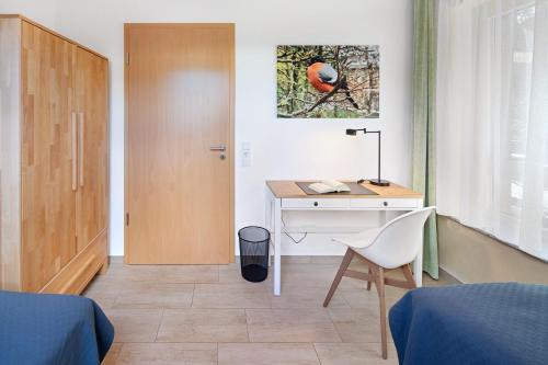 a bedroom with a desk and a chair and a door at Leben am Weinberg in Herbstein
