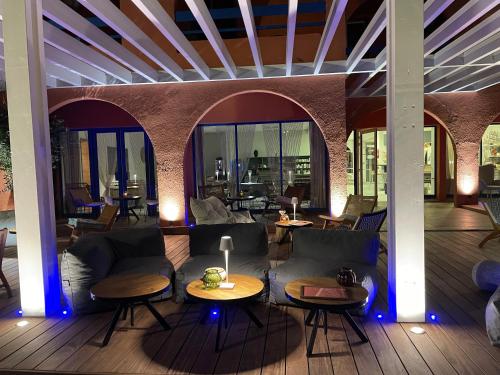a living room with couches and tables and windows at Cit'Hotel des 2 Golfs in Port Leucate