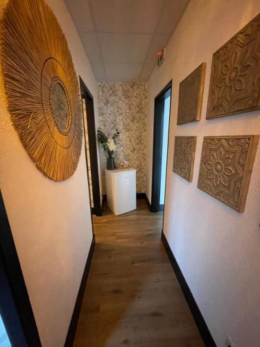 a hallway with art on the walls of a room at Cit'Hotel des 2 Golfs in Port Leucate