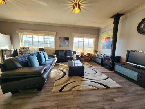 a living room with a couch and a tv at Beautiful vineyard stay in Howrah