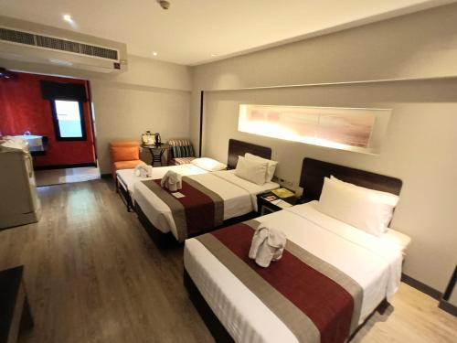 Postel nebo postele na pokoji v ubytování Nouvo City Hotel