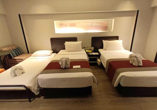 Postel nebo postele na pokoji v ubytování Nouvo City Hotel