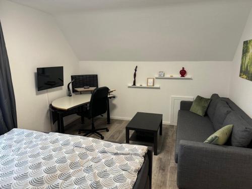 a living room with a couch and a desk with a computer at Ferienwohnung Lippstadt in Lippstadt