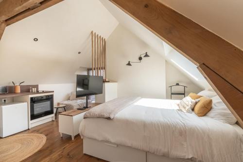 une chambre avec un lit blanc et une télévision dans l'établissement Studio cosy sur la Cote d Opale proche de la mer, à Boulogne-sur-Mer