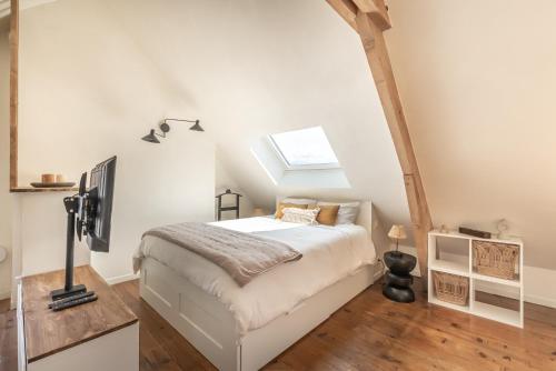 une chambre avec un lit et une lucarne dans l'établissement Studio cosy sur la Cote d Opale proche de la mer, à Boulogne-sur-Mer