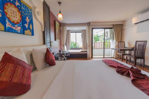 a bedroom with a large white bed with red pillows at BP Chiangmai City Hotel in Chiang Mai