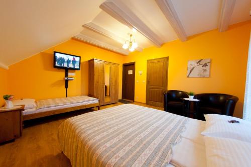 a hotel room with a large bed and a flat screen tv at Willa pod Czantorią SPA Ustroń in Ustroń
