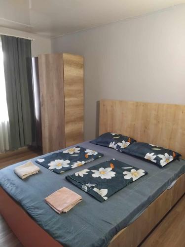 a bed with a blue blanket with flowers on it at Lili's Flat in Angisa