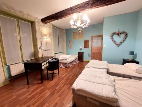 - une chambre avec 2 lits, un bureau et un mur au cœur dans l'établissement Voyage en Confluence - Candes St Martin, à Candes-Saint-Martin