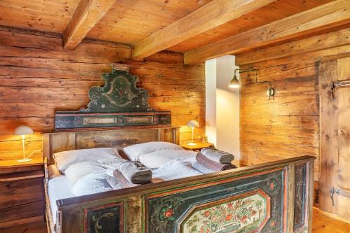 a bed in a room with wooden walls and ceilings at Altes Totschenhäusl am Ziller in Finsing