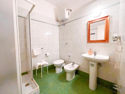 a bathroom with a sink and a toilet and a mirror at Ostello Bello Firenze in Florence